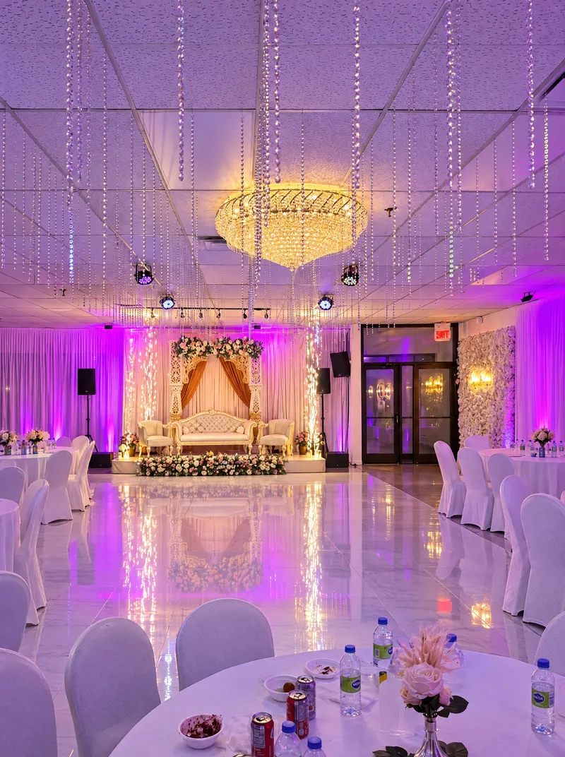 La salle de réception en soirée, lustre en cristal et tables dressées